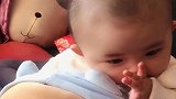 这个小宝贝真可爱，趴在毛绒玩具上，太萌了！
