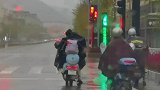 下雨天女孩坐后座上书包被淋，费劲整理时陌生人出手帮忙整理好