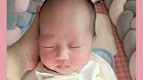 小宝宝这睡觉的样子真可爱，尤其在妈妈手里的时候，真像个假娃娃