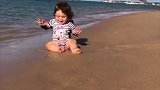 小宝宝第一次坐在沙滩上，开心的样子把心都萌化了！