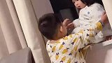 哥哥试图将妹妹从窗台上抱下来，结果俩人都摔地上了