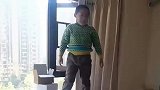 男孩从窗边跳到床上，爸爸见状不断鼓舞