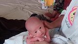 小宝宝趴在妈妈的手上，小眼神好可爱，真是让人萌化了！
