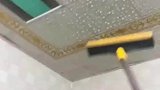 回南天天花板积水，屋主用刮板将积水刮下来