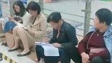 围棋比赛场外等待人群中一位老师在认真批改学生试卷  网友：她一定是位很好的老师（剪辑：小焱）