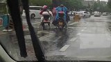 好心大姐把雨衣脱下来送给淋雨的小女孩