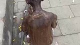 小男孩全身漆黑，不知道的还以为是雕像