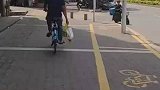 男子提着奶茶骑共享单车，袋子破了奶茶快要掉出来