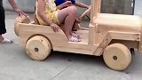 爷爷给孙子做了辆实木汽车，孙子开上街那叫一个神气