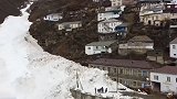 俄罗斯一村庄遭雪崩突袭之后，道路两旁筑起高达18米雪墙