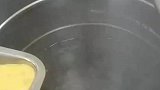 厨师将蛋液倒入热水中，做真正的蛋花汤