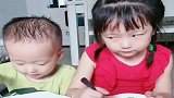 姐姐吃得正香，弟弟非要来抢，姐弟俩这小眼神一看就是一个妈生的