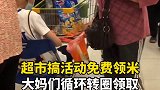 超市搞活动免费领米，大妈们循环转圈领取。