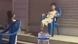 男童坐在椅子上，看女孩跳舞