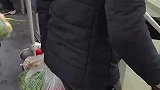 公交车停车开门，男人们都提着菜往家赶
