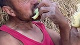 男子田间地头休息，满足的吃着干粮和瓜果