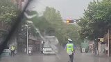 交警雨中坚守岗位，车上学生丢出雨伞相赠