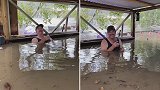 澳洲：暴雨引发洪水房子被淹，男子坐在洪水里淡定喝啤酒