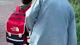 弟弟接姐姐放学非要替姐姐背书包，没想到被书包压的站不起来