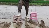 男子想用椅子过泥地，不料翻车失败