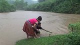 下雨发洪水，美女河里捞鱼，还真抓到两条！