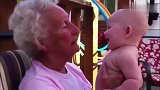 老祖母抱着小孙子聊天，一脸的慈爱的看着小宝宝，怎么爱都爱不够