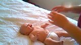 宝宝躺在床上，妈妈给他挠痒痒，宝宝乐嗨了，小模样太招人疼爱了