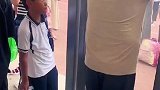 男孩盯着来接他的家长偷笑不出声