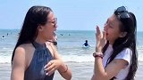 两位女生在海边拍照，拍照动作略显”做作“，但是成果显著