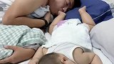 爸爸和宝宝一起睡觉，宝宝把脚伸到爸爸嘴里