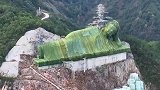 浙江大山里的一座卧佛，全身盖了一层绿色纱网，这是何用意？