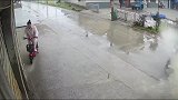 女士骑电瓶车在同一个地方，不到两分钟时间被溅了两次水