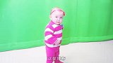 Emilia萌宝站在绿布前,有点呆萌有点滑稽,太可爱了