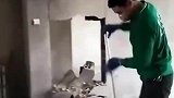 工人抡锤砸墙，将门框的位置砸开