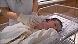 护士在给新生宝宝量体温，小宝宝好乖啊！貌似还笑了