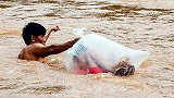 心酸！越南洪水泛滥河流齐脖深 家长用塑料袋运孩子过河上学