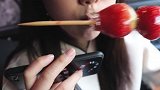 小姐姐吃甜蜜蜜的草莓糖葫芦，咬起来嘎嘣脆，看着就想吃
