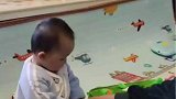 爸爸正在带娃，萌娃拿娃娃就非要拿走逗他