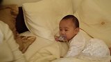妈妈拍打闹钟，宝宝立马笑眯了眼，都要笑岔气了还不忘嘴里奶嘴