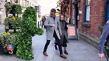 男子在街头伪装成草人捉弄路人，面前的路人纷纷被吓