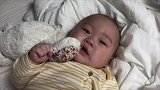 肉嘟嘟的小宝宝自己躺着自娱自乐，丰富的表情把妈妈都逗笑了！