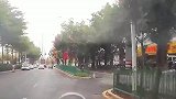白色轿车拐弯占两车道，视频车见状变道避让