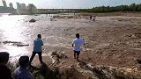 永定河通水到固安段，附近村民游客闻讯赶来，大爷粪叉中两条大鱼
