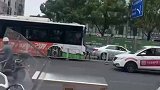 大妈站在公交车前方挡着，使公交车不能正常运行