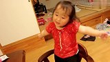 小妹子很活泼，不好好吃饭，站在椅子上玩耍