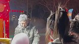 大爷在室外卖棉花糖，头和衣服被棉花糖黏住