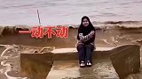 听从摄影师指挥，美女在海浪中静待神来之笔