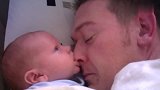 小宝宝和爸爸一起睡，突然饿了，张嘴就啃起了爸爸的鼻尖