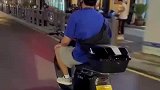 男子骑电动车上路，不需要操控车头