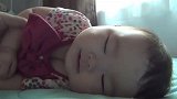 小宝宝睡着被妈妈调戏，露出了甜甜的微笑，这醒来姿势简直甜到化